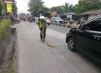 Bahayakan Pengguna Jalan Polisi Bersihkan Ceceran Pasir Dan Kerikil Di Jalan. 