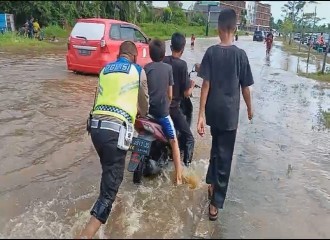 Polantas Pekanbaru Bantu Dorong Kendaraan Warga Yang Mogok Terjebak Banjir